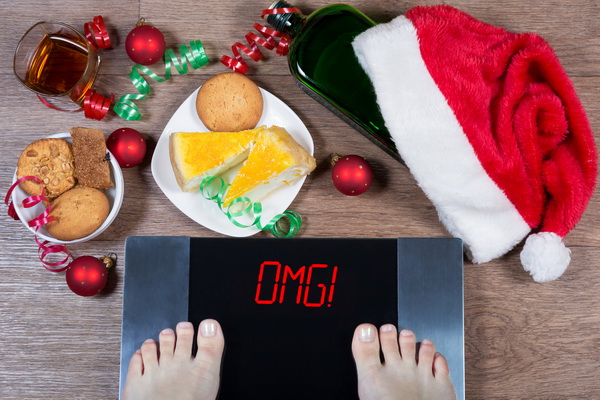 Female feet on digital scales with sign "omg!" surrounded by unhealthy food choices