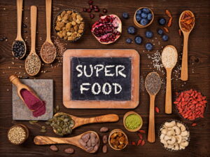 Super foods in spoons and bowls on a wooden background