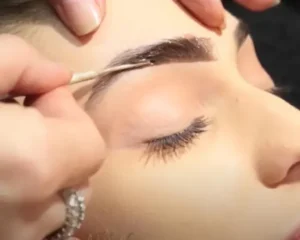 application of brow stain on a women with her eyes closed