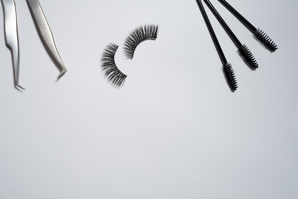 Flat Lay of Eyelash Brushes and False Lashes on White Background