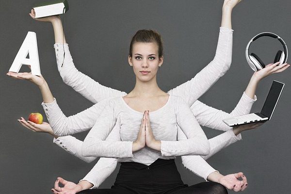 women sitting in lotus position juggling multiple tasks