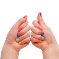 little girls nails painted with rainbow colours