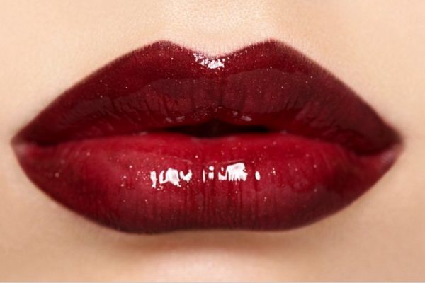 closeup of a woman's lip wearing red lipstick