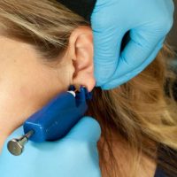 women getting ear piercing
